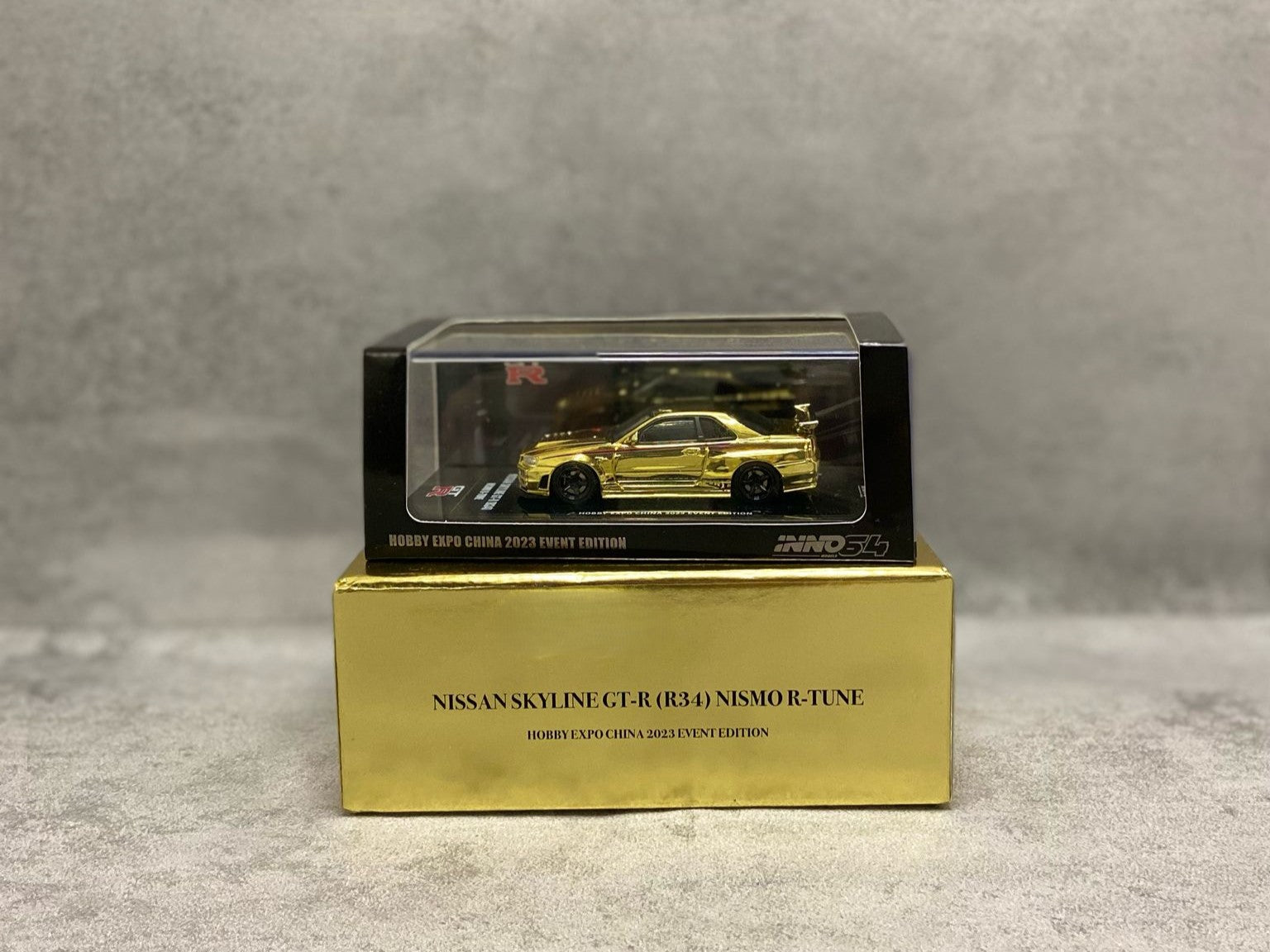 Inno64 GT-R R34 Nismo R-Tune Gold – mașinuță JDM 1:64 premium cu cutie acrilică

